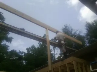 Carpenter setting a ridge beam over a new addition frame — Ice Dam Removal by Roofing Brothers in Culver City